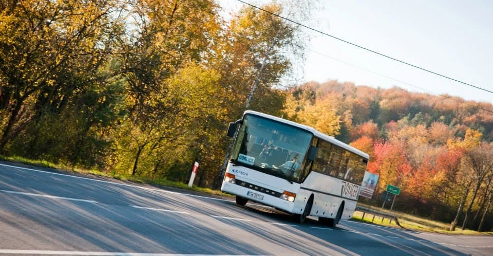 Setra Voyagera na drodze wśród jesiennych drzew